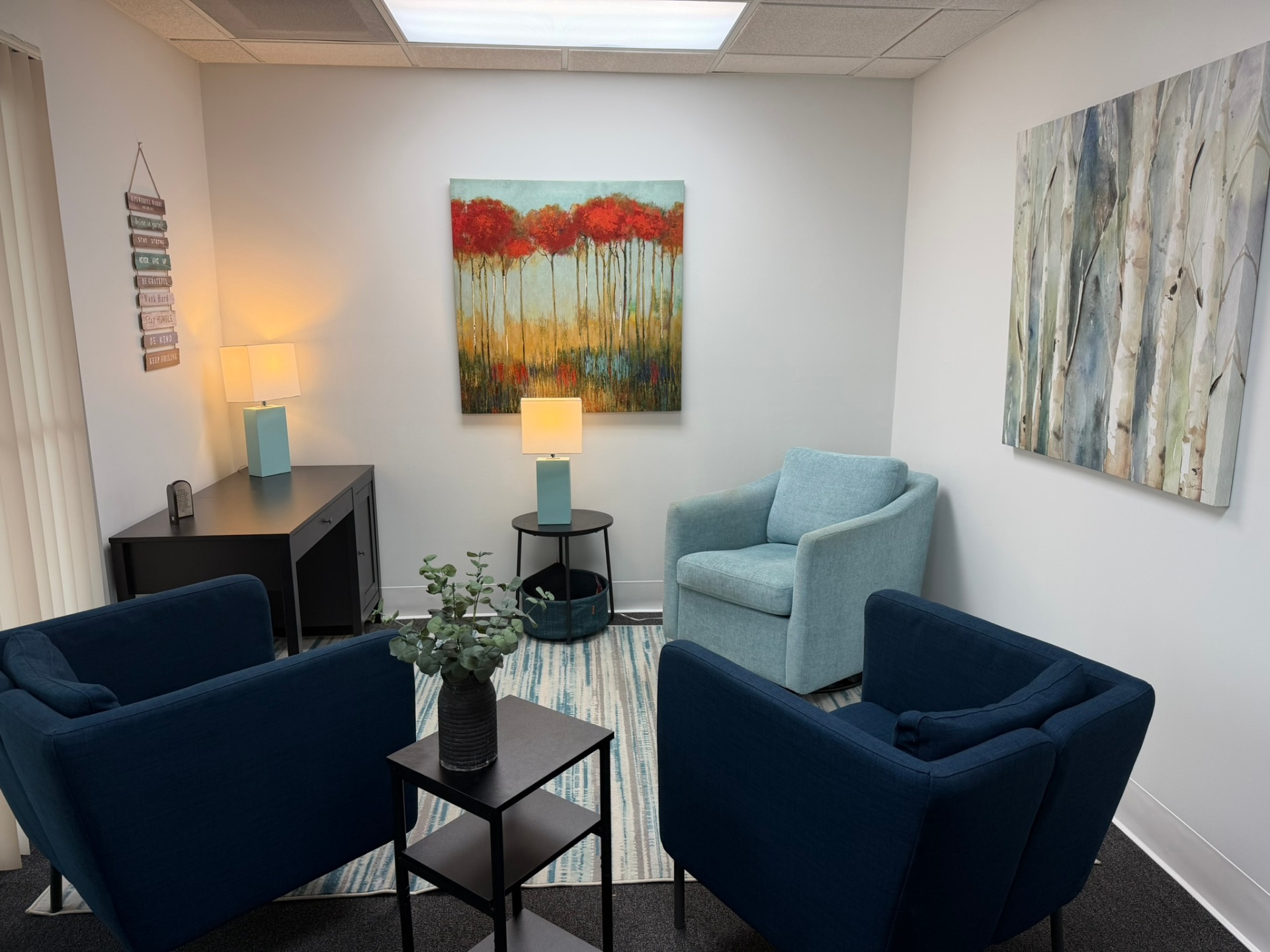 Maria's Weston, FL therapy office — navy chairs, soft teal accent chair, warm lamps
